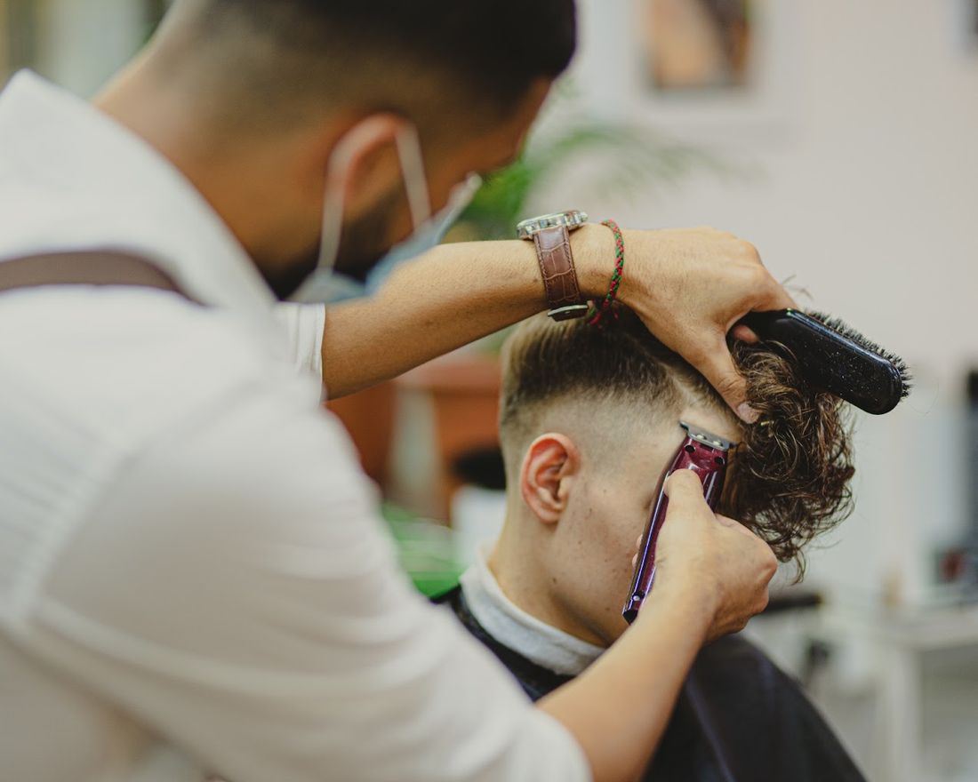 Barbero de Deodi trabajando un corte con tijera y peine